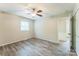 The bedroom features neutral walls, updated vinyl flooring, a ceiling fan, and a window at 711 September Ln, Charlotte, NC 28208
