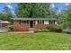 Charming single-story brick home featuring black shutters and a well-maintained front yard at 711 September Ln, Charlotte, NC 28208