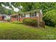 Well-maintained single-story brick home with black shutters and lush, green front yard at 711 September Ln, Charlotte, NC 28208