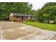 Charming single-story home boasting brick accents, dark shutters, and a wide concrete driveway at 711 September Ln, Charlotte, NC 28208