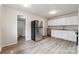 Updated kitchen featuring white cabinets, laminate flooring, and stainless steel appliances at 711 September Ln, Charlotte, NC 28208