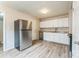 Functional kitchen featuring white cabinets, laminate flooring, and updated stainless steel appliances at 711 September Ln, Charlotte, NC 28208