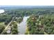 Expansive aerial perspective revealing the home nestled amidst trees and bordering the calm lake at 7232 Executive Cir, Denver, NC 28037