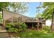 Multi-tiered wooden deck of home with manicured shrubs, lush greenery, and landscaped features at 7232 Executive Cir, Denver, NC 28037