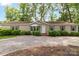 Inviting home with gravel driveway, manicured shrubs, and well-maintained lawn providing a welcoming entrance at 7232 Executive Cir, Denver, NC 28037