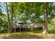 Exterior view of house with a deck surrounded by trees, creating a tranquil outdoor retreat at 7232 Executive Cir, Denver, NC 28037