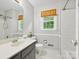 Well-lit bathroom featuring a vanity, mirror, and tiled shower with a window at 7317 Red Branch Ln, Charlotte, NC 28226