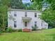 Charming two-story home with a well-manicured lawn, brick steps, and surrounded by mature trees at 7317 Red Branch Ln, Charlotte, NC 28226