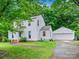 Charming two-story home with a lush green lawn and mature trees, complemented by a detached garage and ample parking space at 7317 Red Branch Ln, Charlotte, NC 28226
