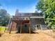 Backyard view of a two-story home with a deck and a fenced yard creating a secure and private outdoor space at 7737 Batavia Ln, Charlotte, NC 28213