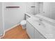 Neutral bathroom with an extended vanity, large mirror, toilet, and wood-look floors creating a clean and functional space at 7737 Batavia Ln, Charlotte, NC 28213