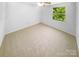 Bedroom features neutral carpet, bright natural light, and ceiling fan at 7737 Batavia Ln, Charlotte, NC 28213
