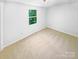 Well-lit bedroom with neutral carpet, a bright window, and electrical outlets, ready for customization at 7737 Batavia Ln, Charlotte, NC 28213