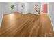 Spacious living area with hardwood floors, a staircase, and a bright pink front door at 7737 Batavia Ln, Charlotte, NC 28213