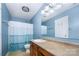 Bright bathroom with blue walls, a vanity sink, a mirror, a shower, and a toilet at 826 Sinclair Dr, Monroe, NC 28112