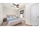 Staged bedroom featuring stylish bed with blue pillows and blanket, rug, and nightstands at 826 Sinclair Dr, Monroe, NC 28112