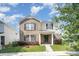Charming two-story home with brick and siding exterior, complemented by green shutters and landscaping at 826 Sinclair Dr, Monroe, NC 28112