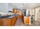 A kitchen with wood cabinets, black countertops, stainless steel appliances, and hardwood floors at 826 Sinclair Dr, Monroe, NC 28112