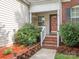 Inviting front porch with brick steps, white railings, and decorative plants creating a welcoming entrance at 9348 Golden Pond Dr, Charlotte, NC 28269