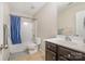 Neutral-toned bathroom with a bathtub, shower, vanity, and blue shower curtain at 9524 Eagle Feathers Dr, Charlotte, NC 28214