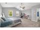 Bright bedroom with a ceiling fan, neutral paint, two sunny windows, and luxury vinyl plank flooring at 9524 Eagle Feathers Dr, Charlotte, NC 28214