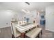 Open dining area featuring contemporary lighting, a large glass table, and views into the kitchen at 9524 Eagle Feathers Dr, Charlotte, NC 28214