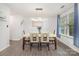 Bright dining area with modern light fixture, wood-look floors, and a large window at 9524 Eagle Feathers Dr, Charlotte, NC 28214