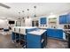 Modern kitchen with blue cabinets, white countertops, stainless steel appliances, and an island with bar seating at 9524 Eagle Feathers Dr, Charlotte, NC 28214