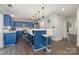 Bright kitchen features a breakfast bar, blue cabinets, stainless appliances, and a subway tile backsplash at 9524 Eagle Feathers Dr, Charlotte, NC 28214