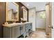 Modern bathroom with dual vanities, framed mirrors, and stylish fixtures over the laminate floor at 977 Myers Mill Rd, Olin, NC 28660