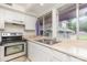 This kitchen features white cabinetry, stainless steel appliances and a double basin sink overlooking the backyard at 10 Cedarvilla Dr, Rock Hill, SC 29730