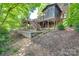 Brick home backyard featuring a raised deck with stairs leading down to a landscaped yard at 10215 Balmoral Cir, Charlotte, NC 28210