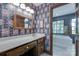 Bathroom showcases floral wallpaper, wood-framed mirror, marble countertop, and soaking tub at 10215 Balmoral Cir, Charlotte, NC 28210