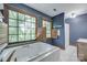 Bright bathroom boasts a large soaking tub, tiled surround, and natural light from two windows at 10215 Balmoral Cir, Charlotte, NC 28210