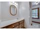 Well-lit bathroom features a wood-framed mirror, white countertop, and shower with glass door at 10215 Balmoral Cir, Charlotte, NC 28210