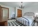 Cozy bedroom features a black iron bed frame, chandelier lighting, and hardwood floors at 10215 Balmoral Cir, Charlotte, NC 28210