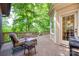 Outdoor deck area with lots of seating, surrounded by trees and nature with a door leading to the house at 10215 Balmoral Cir, Charlotte, NC 28210