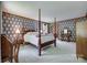 This is a spacious main bedroom with a four-poster bed, nightstands, and floral wallpaper at 10215 Balmoral Cir, Charlotte, NC 28210
