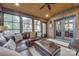 Cozy sunroom with brick accent wall, wood ceiling, and comfortable seating with access to an outdoor patio at 10215 Balmoral Cir, Charlotte, NC 28210