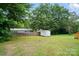 Spacious backyard featuring a shed and wooden fence, with mature trees offering plenty of shade at 107 S Branch St, Monroe, NC 28112