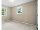 This bedroom has neutral paint, carpet and trim, with windows offering natural light at 107 S Branch St, Monroe, NC 28112