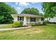 Charming one-story home with a well-maintained lawn, landscaping, and a sidewalk to the front door at 107 S Branch St, Monroe, NC 28112