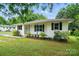 Charming one-story home with a well-maintained lawn, landscaping, and a sidewalk to the front door at 107 S Branch St, Monroe, NC 28112
