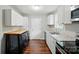 Modern kitchen with stainless steel appliances, white cabinets, and luxury vinyl flooring at 107 S Branch St, Monroe, NC 28112