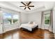Comfortable bedroom with tray ceiling, fan, hardwood floors and sun-filled windows at 1125 Bethel Rd, Charlotte, NC 28208