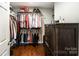 Walk-in closet offers ample storage with built-in shelves and drawers; hardwood flooring throughout at 1125 Bethel Rd, Charlotte, NC 28208