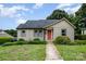 Charming bungalow featuring a well-kept lawn, beautiful landscaping, and eye-catching red front door, ideal for a starter home at 1125 Bethel Rd, Charlotte, NC 28208