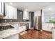 Bright kitchen boasts stainless steel appliances, white cabinets, granite countertops, and hardwood floors at 1125 Bethel Rd, Charlotte, NC 28208