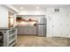 This kitchenette features a stainless steel refrigerator, wooden shelf, and gray cabinets at 1125 Bethel Rd, Charlotte, NC 28208