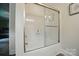 Bright bathroom featuring a white bathtub with a modern sliding glass door and updated fixtures at 1209 Rainbow Dr, Kannapolis, NC 28081